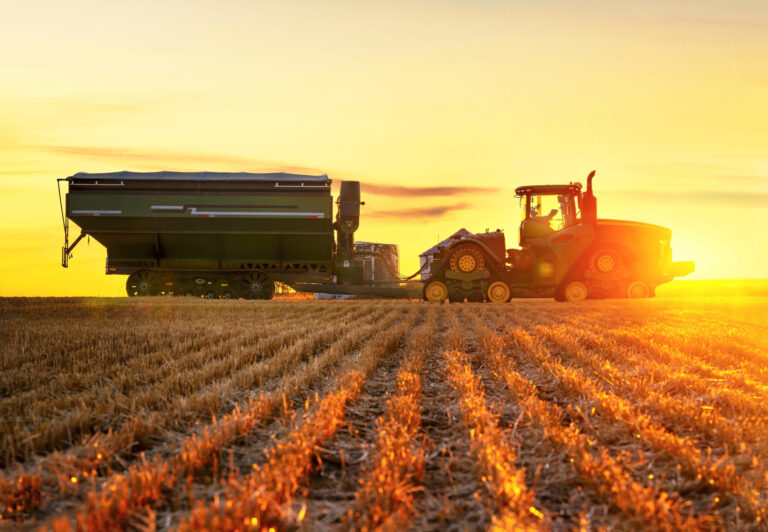 Tractor and grain cart in agricultural field illustrating challenges and opportunities in the agricultural industry.