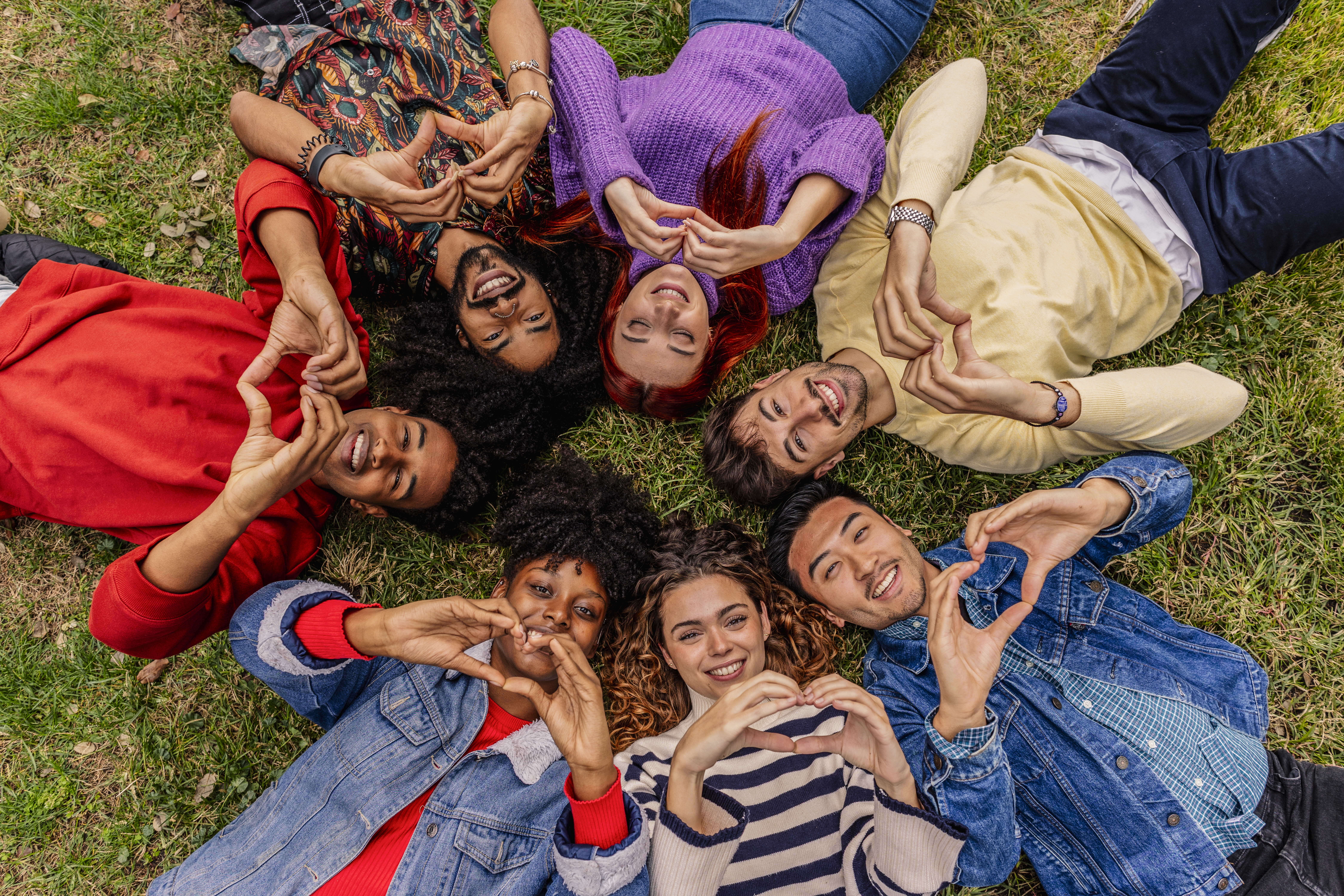 Group of young people forming heart shapes, symbolizing hope and inspiration for youth.