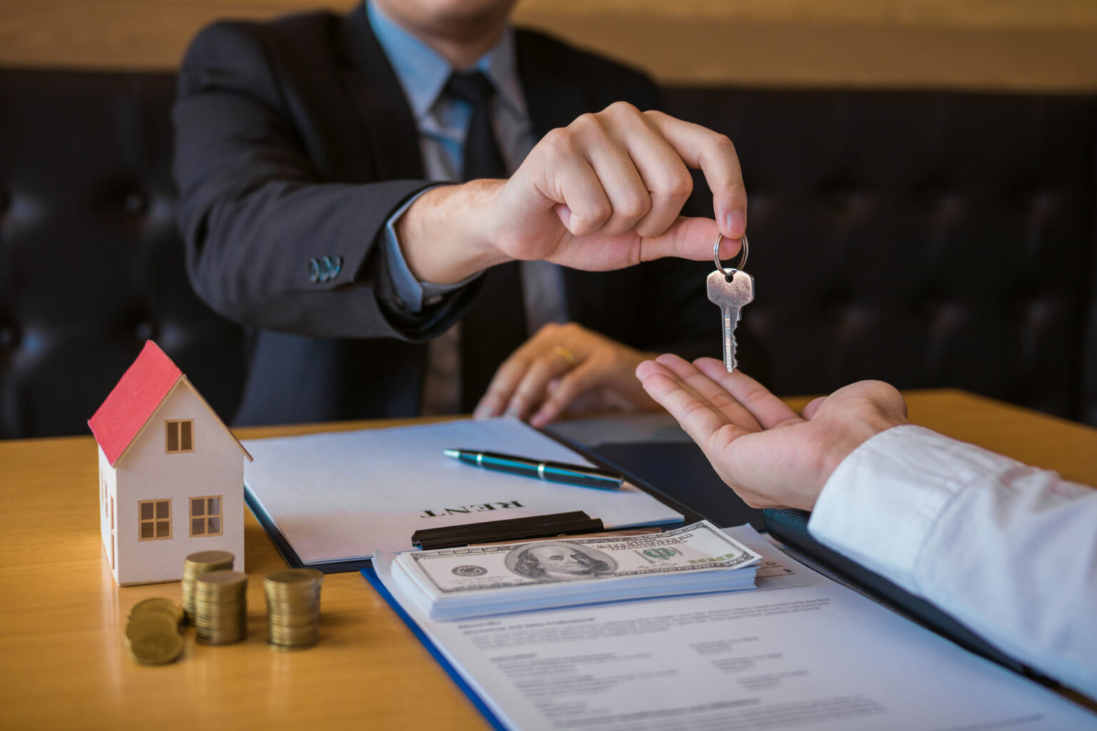 Real estate broker handing keys and cash to new homeowner